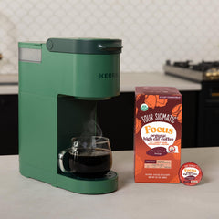 Four Sigmatic opened pod with ground coffee demonstrating rich color