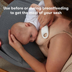 Frida Mom massager positioned above a breast pump flange to aid expression and help clear ducts