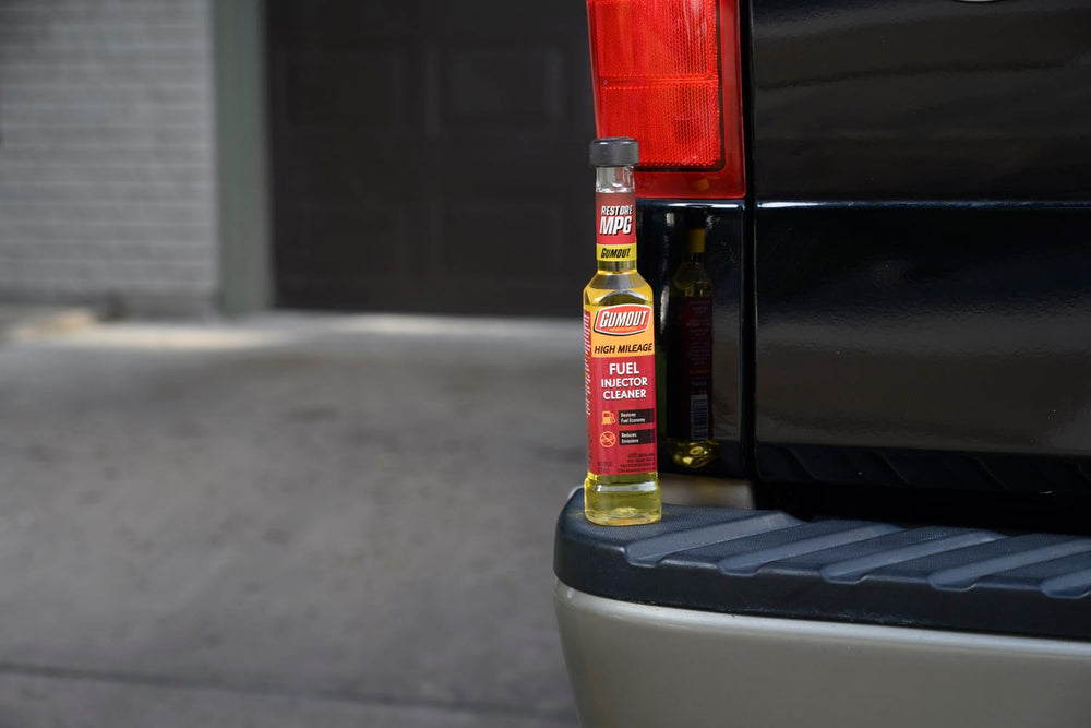 Gumout bottle in garage setting showing professional maintenance readiness