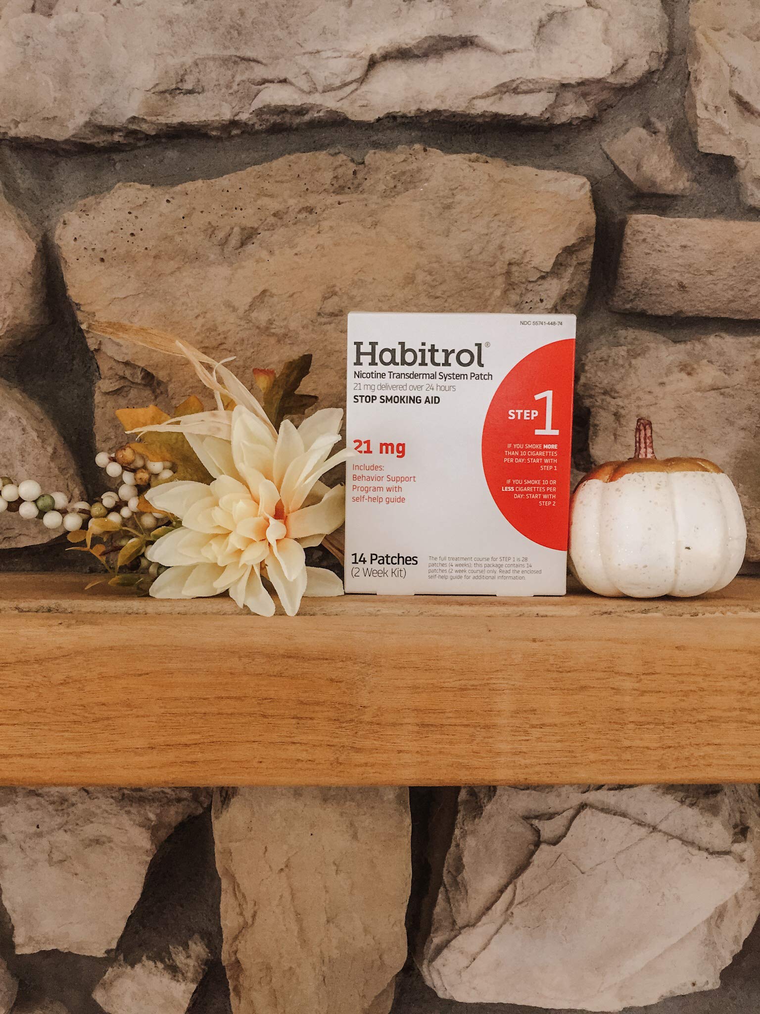 Person applying Habitrol patch to upper arm for all-day nicotine control
