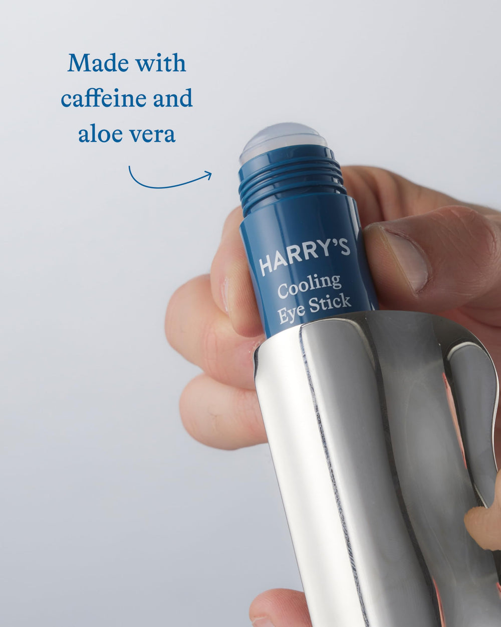 Harry's cooling eye stick held in hand showing portable size and travel benefit