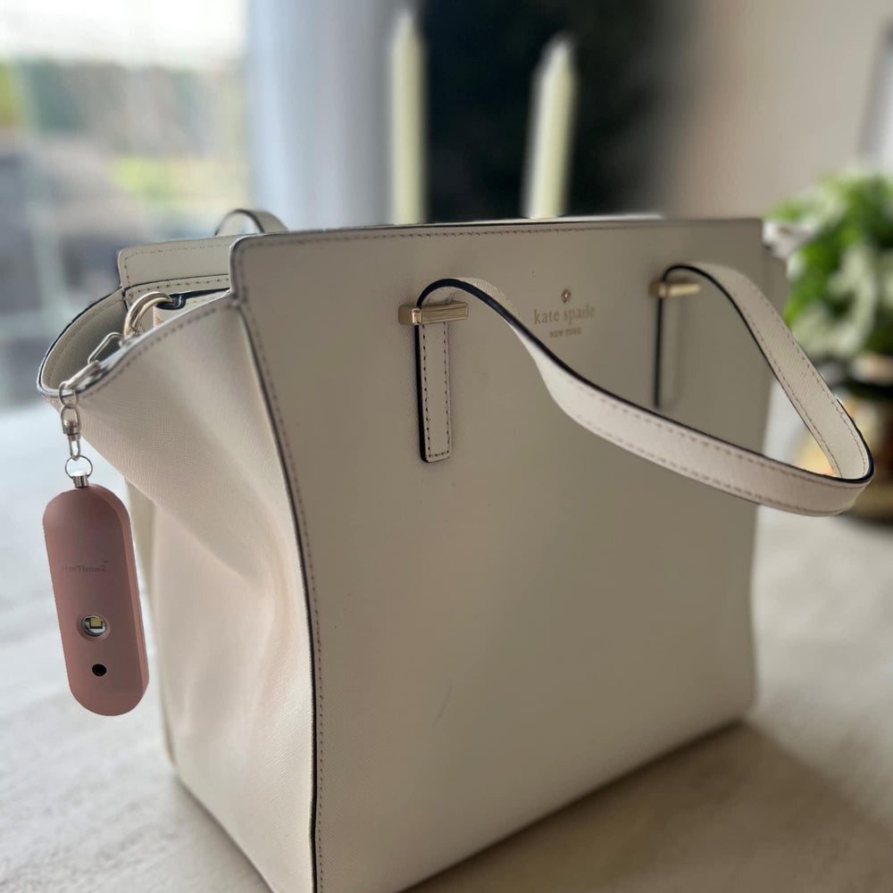 HerTime2 clipped to backpack during evening walk portraying personal safety use
