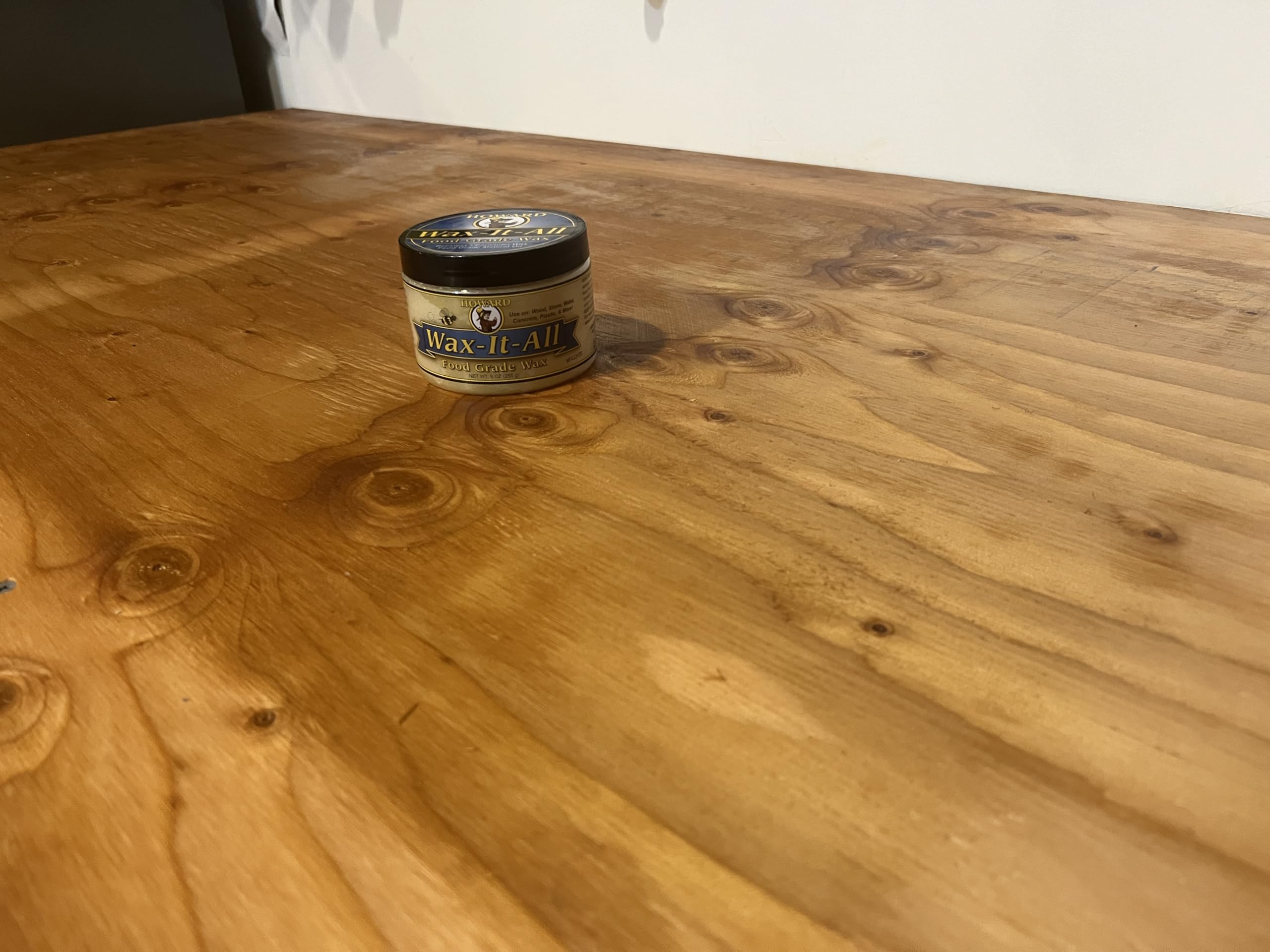 HOWARD 9 fl oz jar next to common objects for scale and coverage