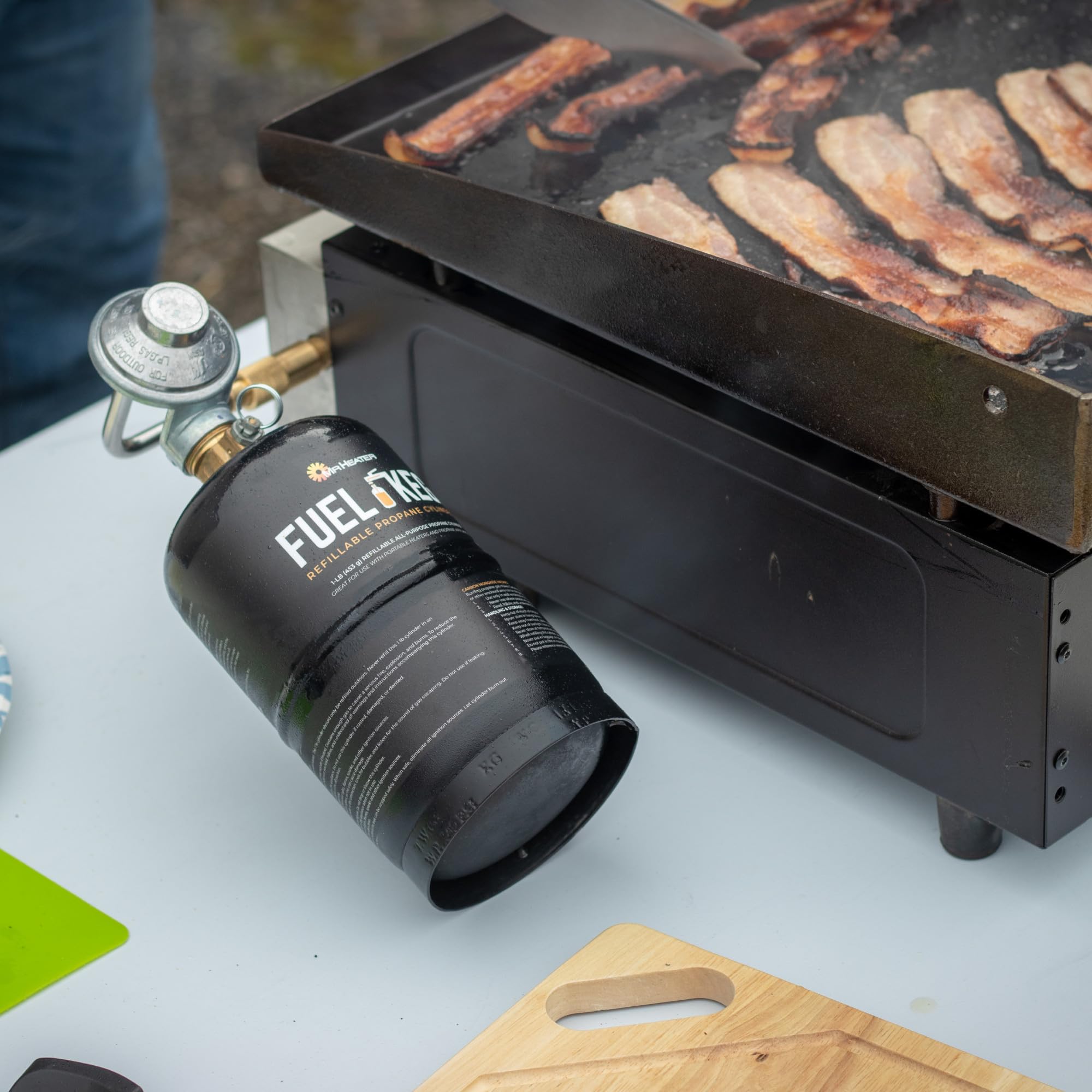 Mr. Heater fuel cylinder connected to an outdoor grill.