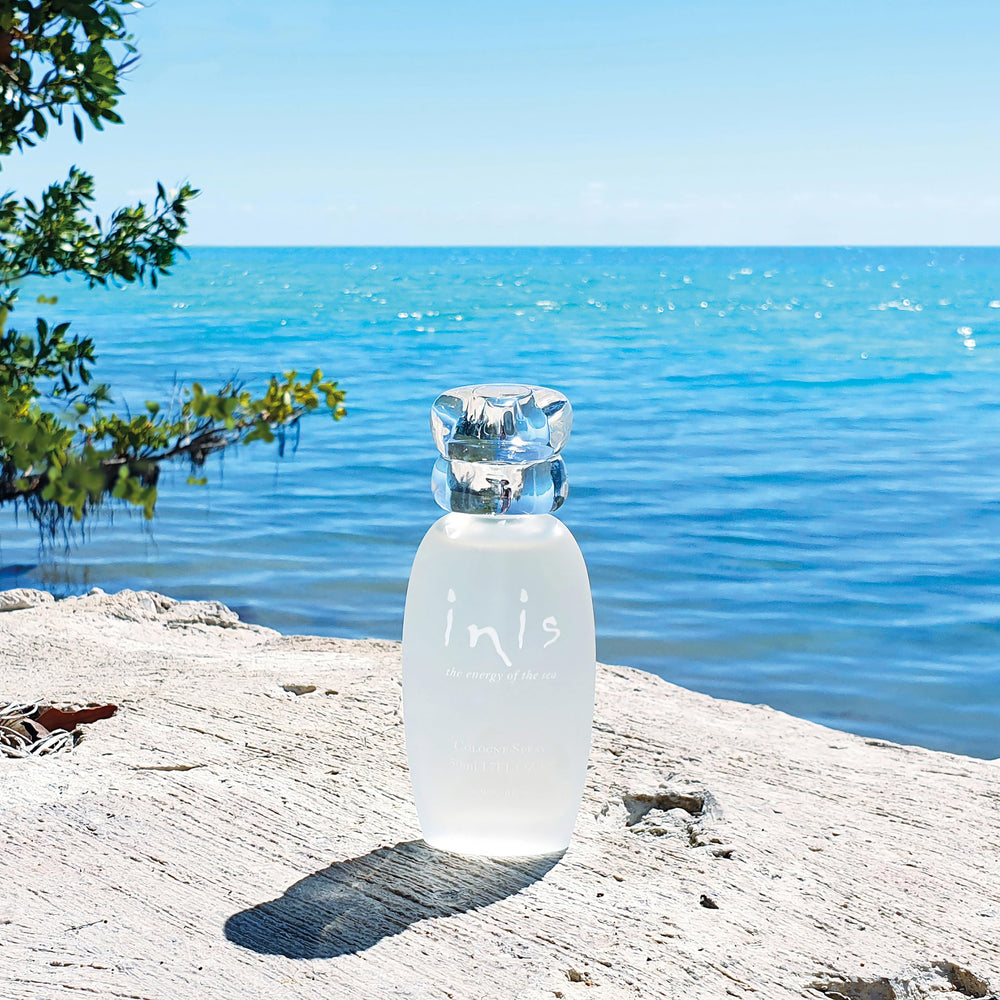 Inis bottle held in hand demonstrating 3.3 fl oz scale and travel-friendly benefit