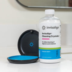INVISALIGN aligner soaking in container showing stain-removal benefit
