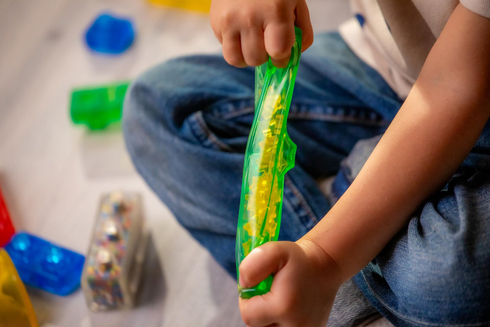 Child hands playing with Jelly Blox, supports fine motor development benefit