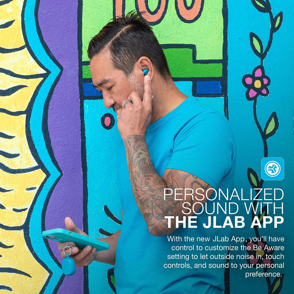 JLab JBuds Mini beside a hand for scale showing small size and travel-ready convenience