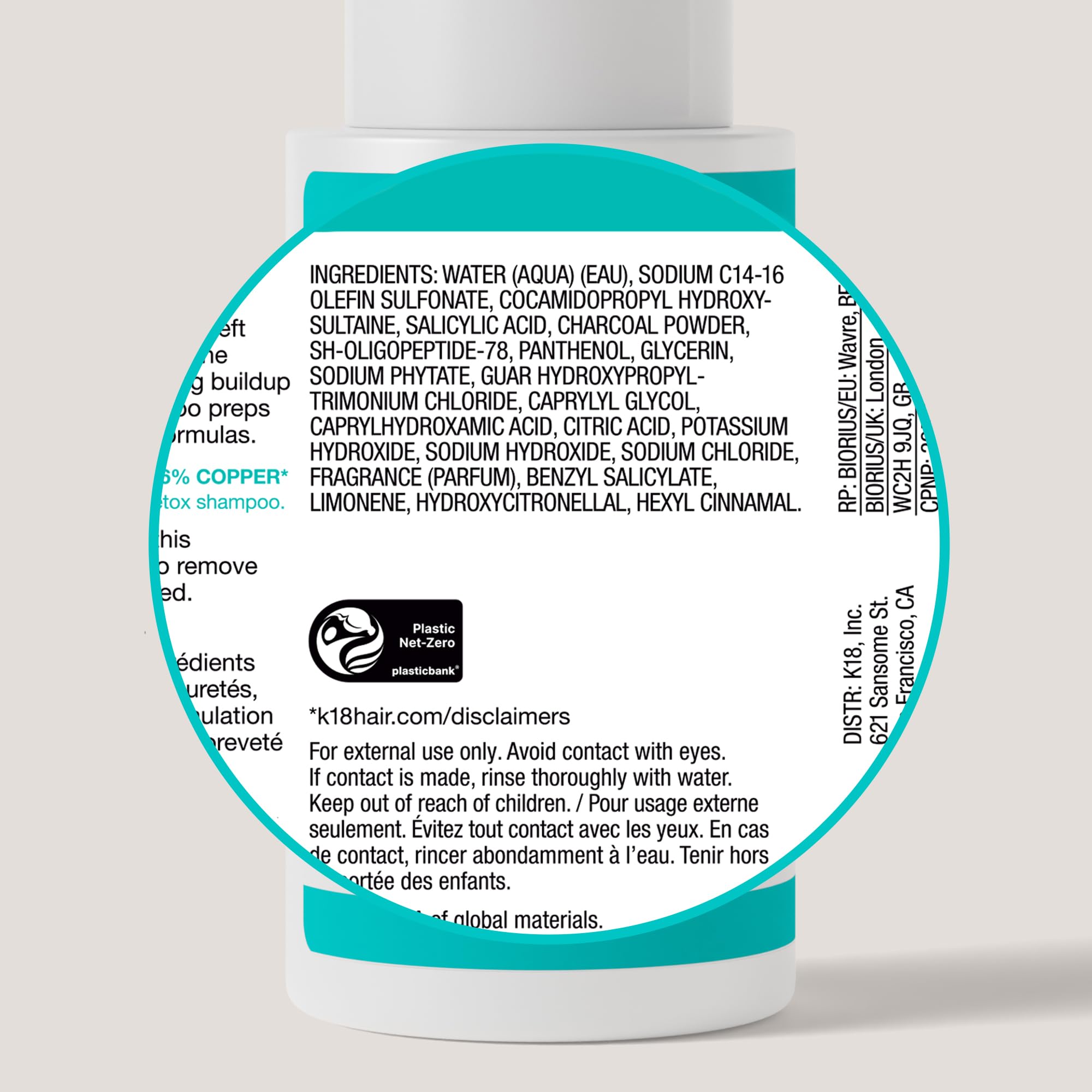 K18 bottle held in hand to show 8.5 fl oz scale and travel-friendly size