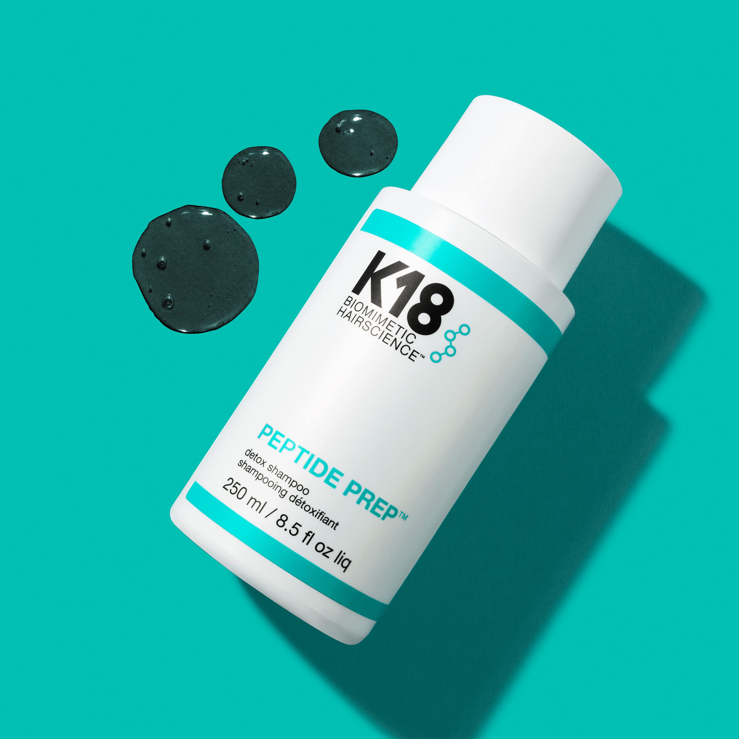 K18 shampoo being massaged into scalp demonstrating targeted buildup removal