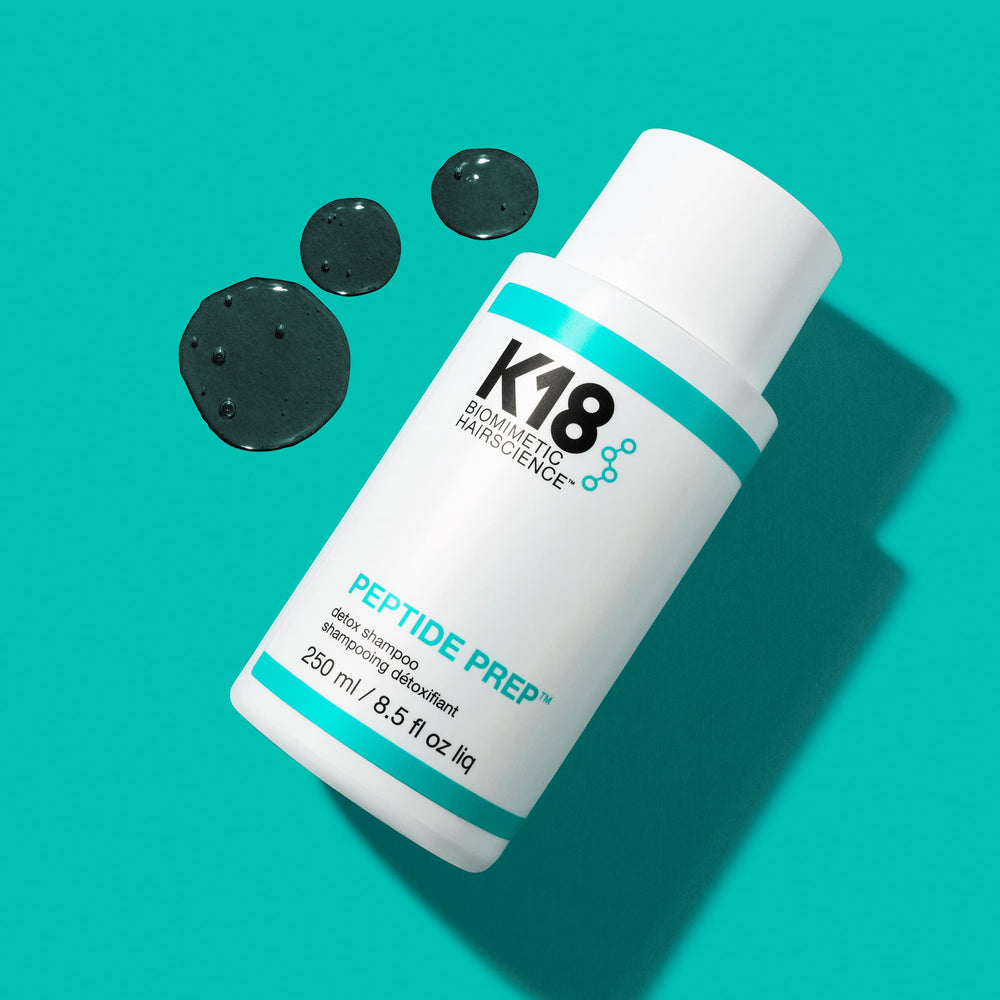K18 shampoo being massaged into scalp demonstrating targeted buildup removal