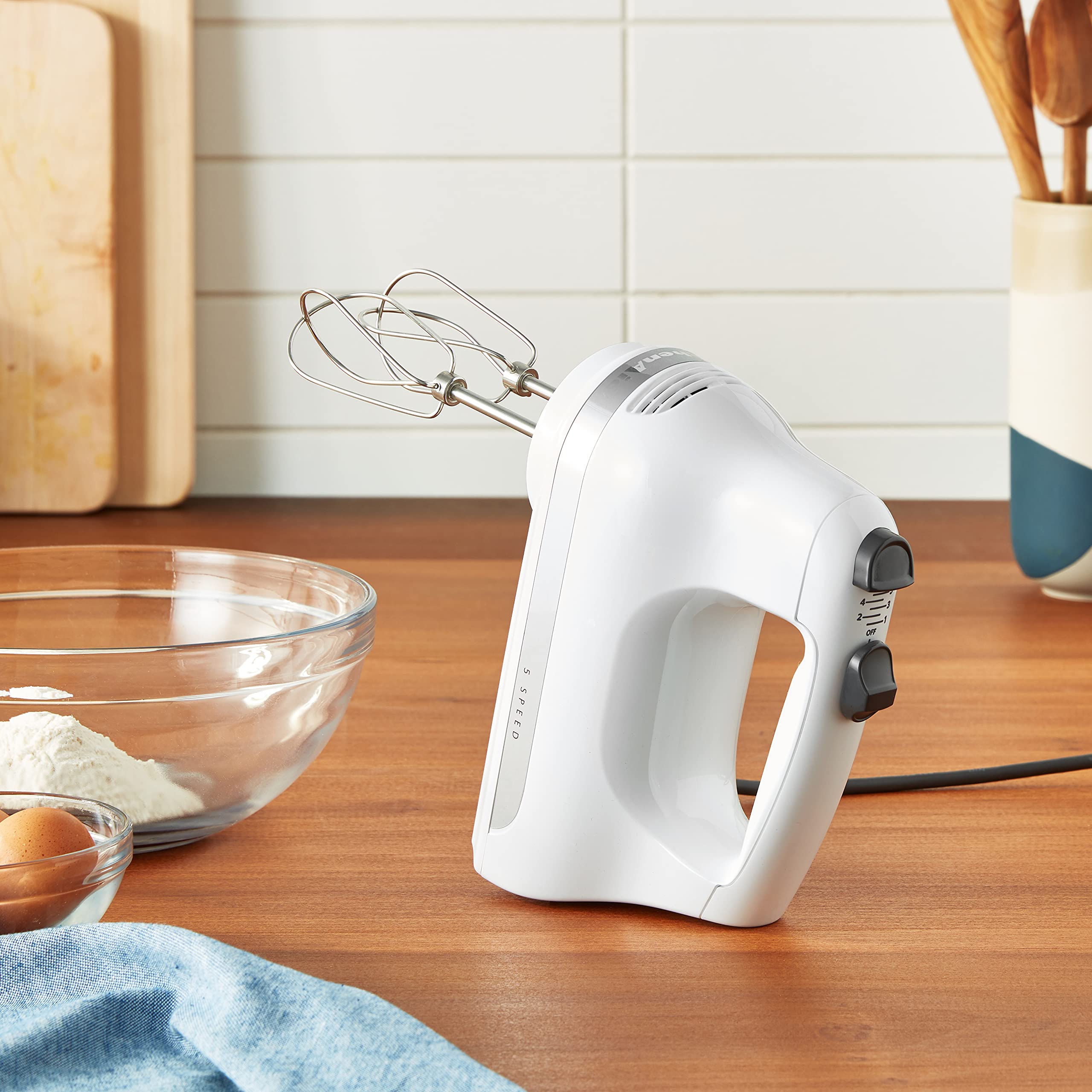 KitchenAid hand mixer in use over bowl demonstrating quick, even mixing benefit