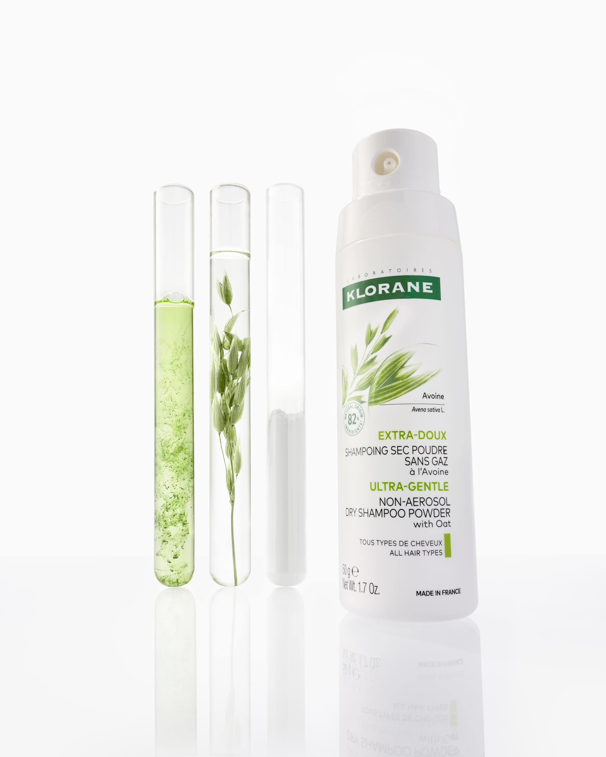 Klorane 1.7 oz oat milk powder placed beside travel essentials to show compact, non-aerosol design