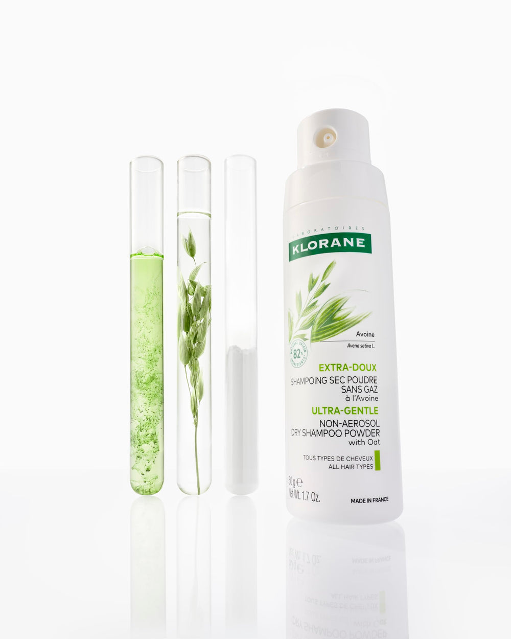 Klorane 1.7 oz oat milk powder placed beside travel essentials to show compact, non-aerosol design
