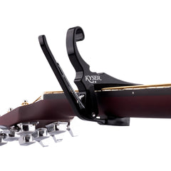 Kyser capo clamped on acoustic fretboard for fast key changes