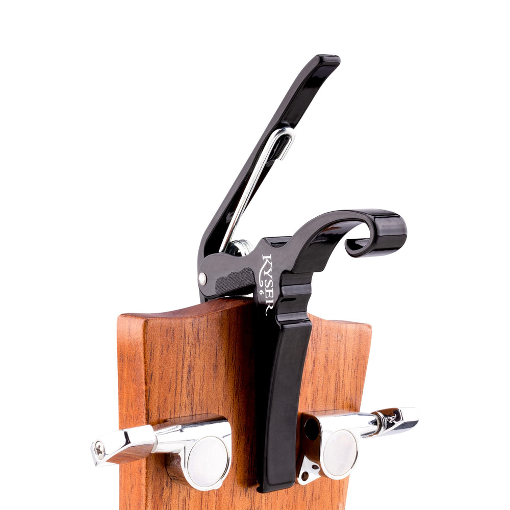 Kyser capo parked on headstock keeping guitar organized and ready