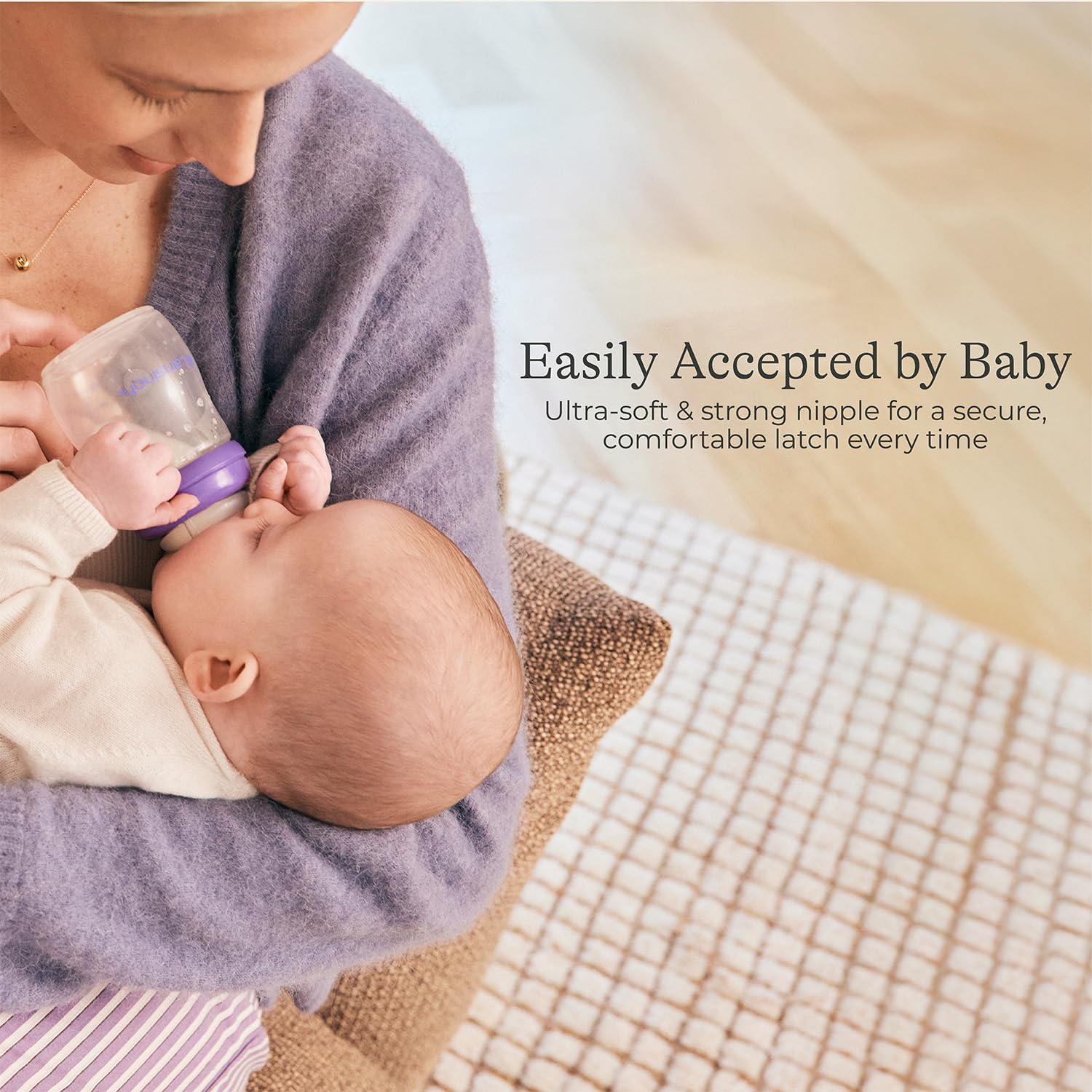 Lansinoh bottle held in hand showing 5-ounce scale and feeding convenience