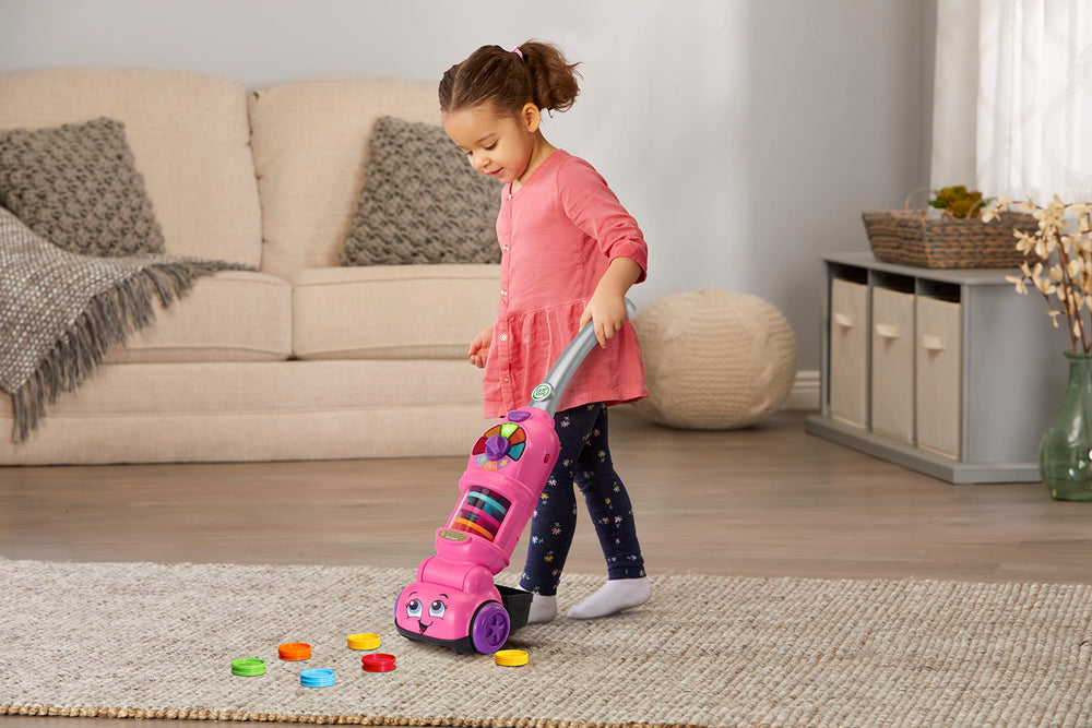 LeapFrog vacuum next to toddler to show product scale and ease of use