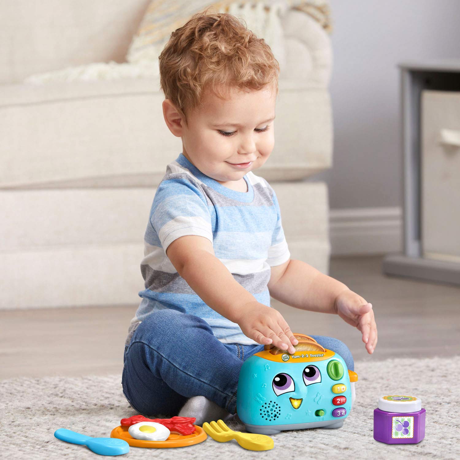 LeapFrog Yum-2-3 Toaster shown next to toddler hand to illustrate child-friendly size and grip