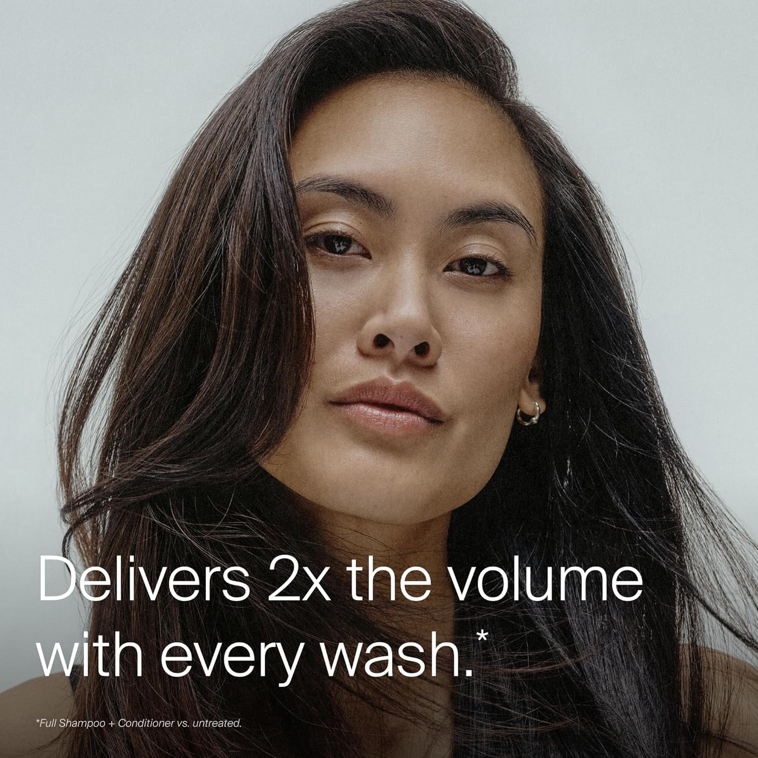 Living Proof full shampoo held in hand to show 8 oz scale and usability