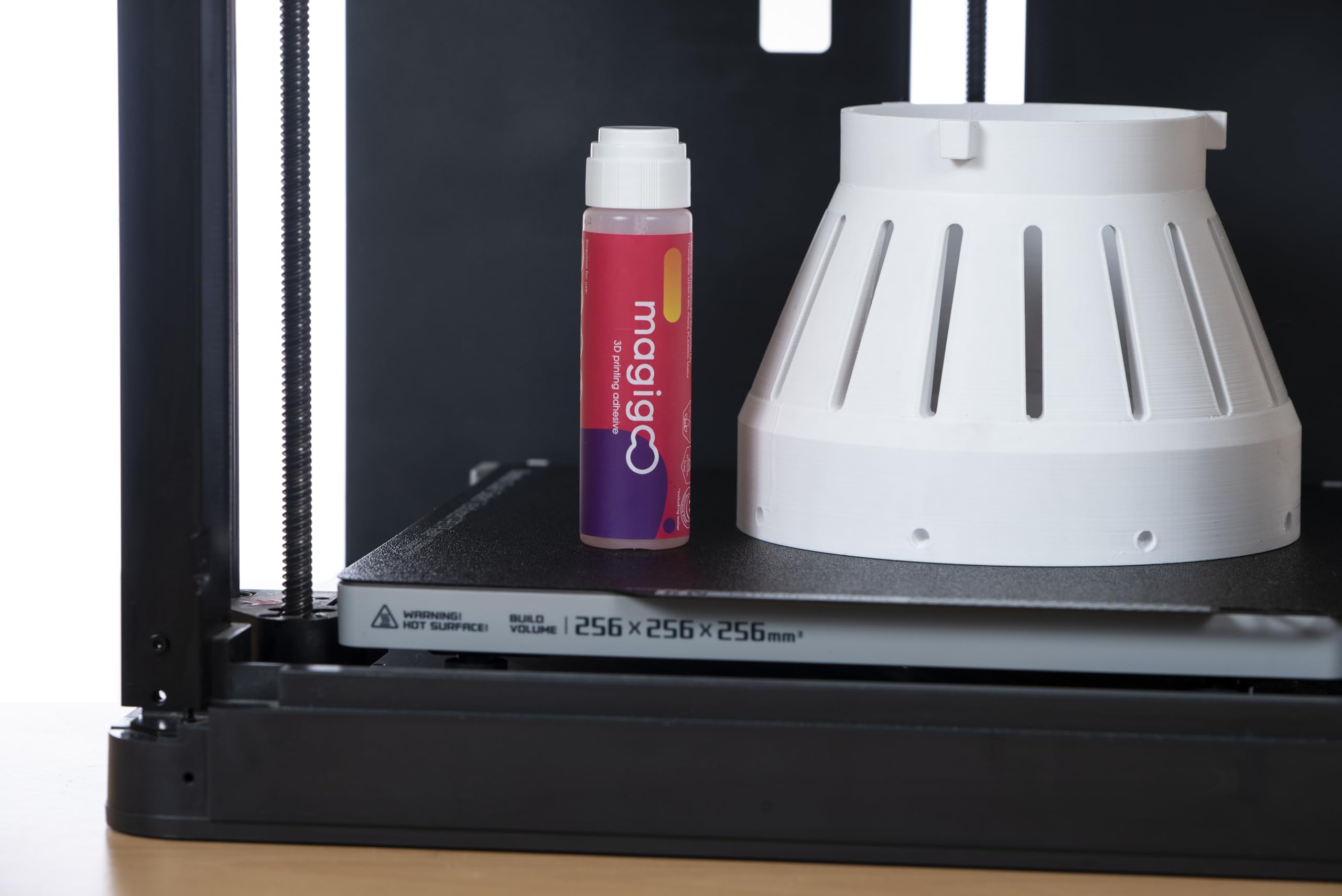 Magigoo 50mL bottle next to a ruler showing compact size and portability