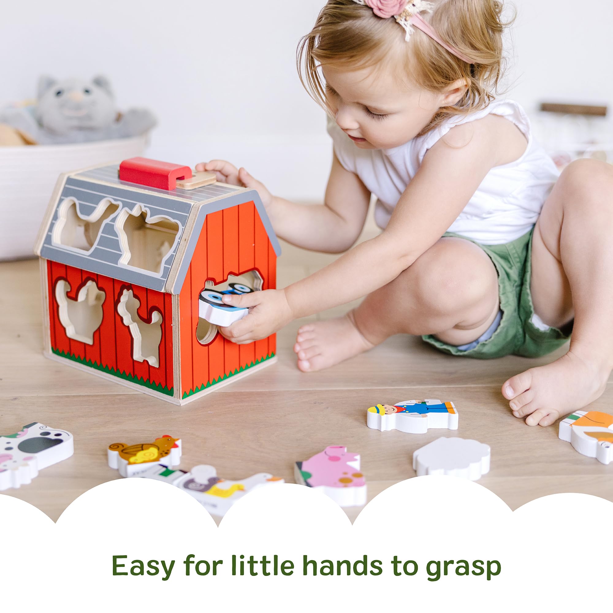 Melissa & Doug barn held in child hands for scale, demonstrates toddler-friendly size