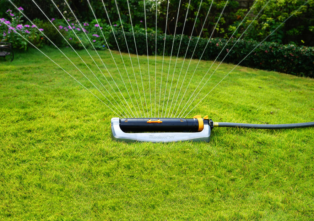 Melnor sprinkler operating on a lawn demonstrating broad, even spray