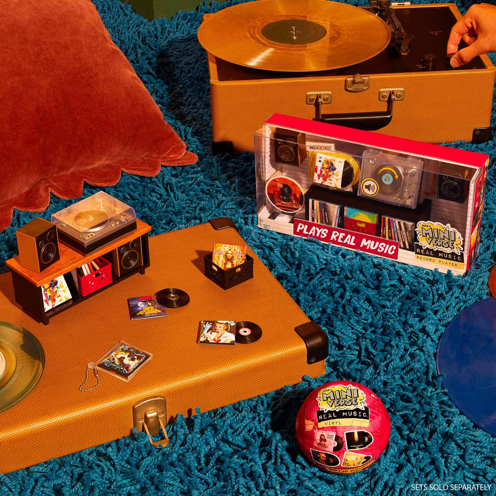 MGA's Miniverse on a desk among books and plants, enhancing room decor with nostalgia