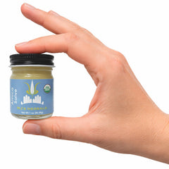 MJ's Herbals ingredients display with arnica flowers and olive oil emphasizing organic quality