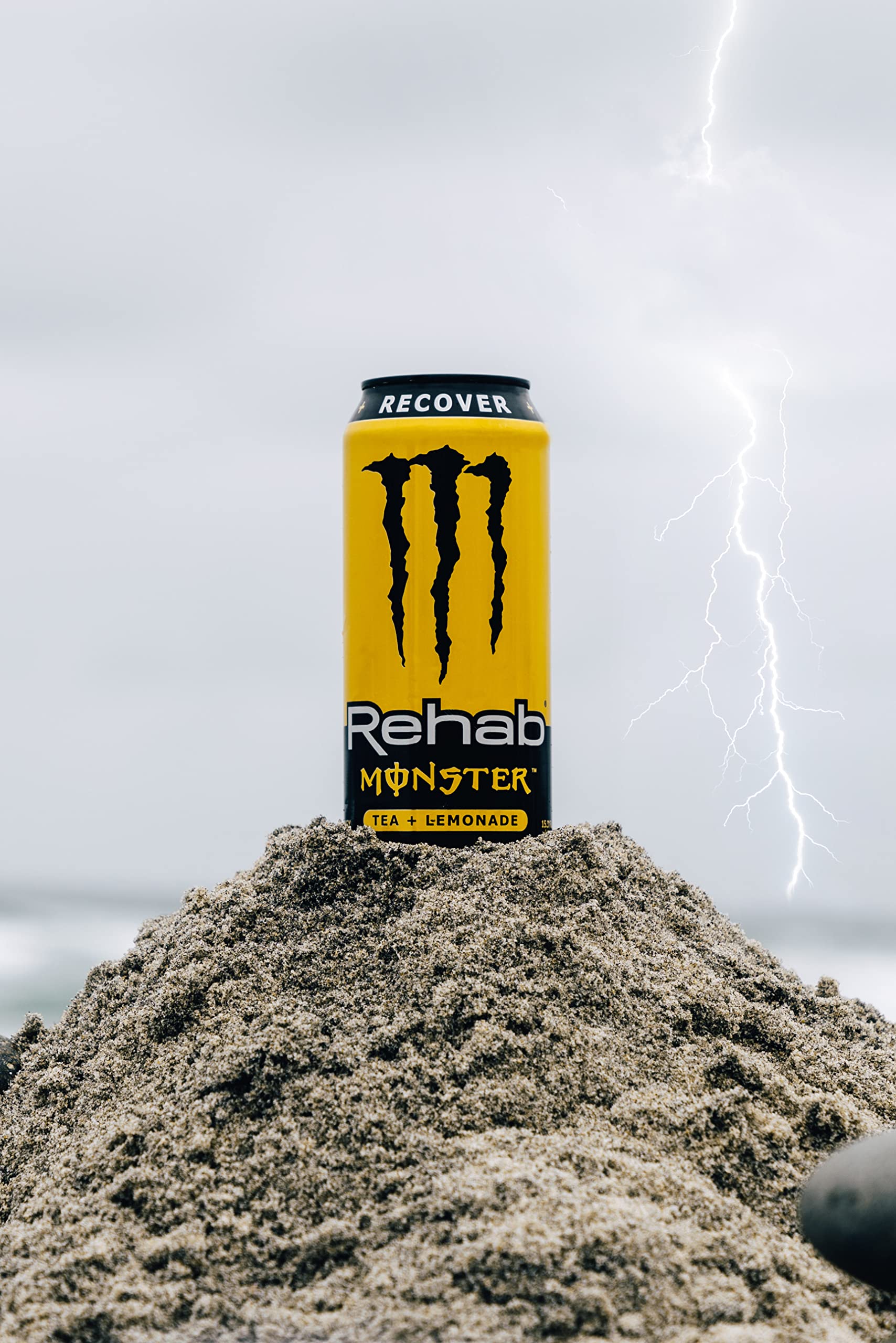 Outdoor scene with Monster Rehab can providing a refreshing energy boost