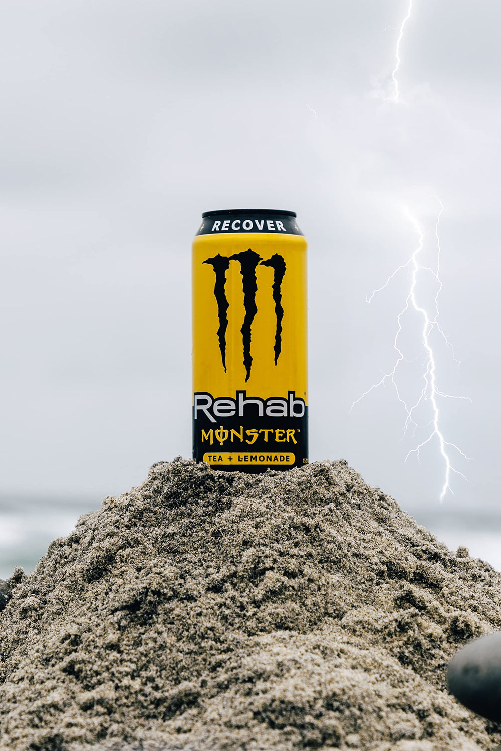 Outdoor scene with Monster Rehab can providing a refreshing energy boost