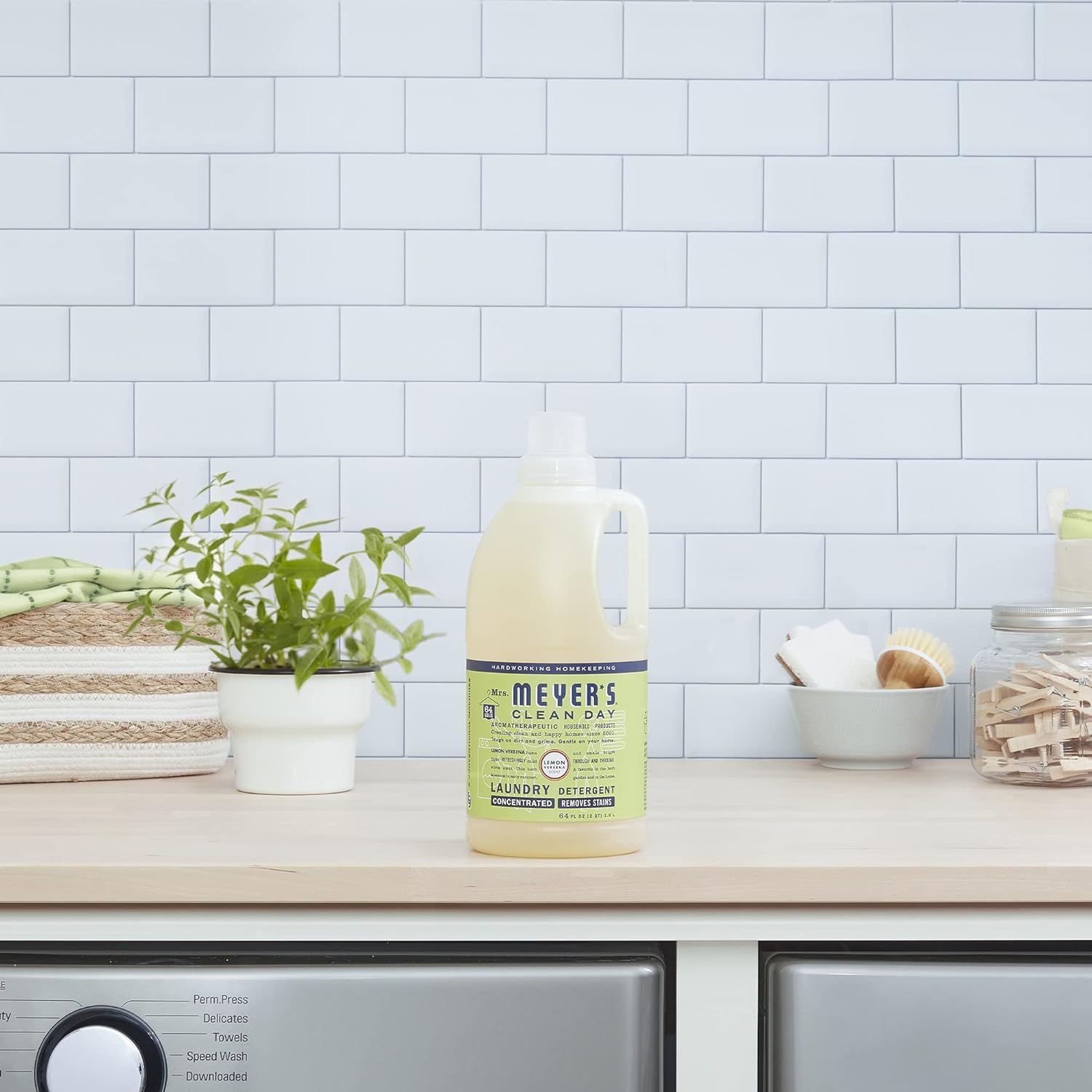 Mrs. MEYER'S bottle with laundry basket and fresh linens suggesting light lemon verbena freshness