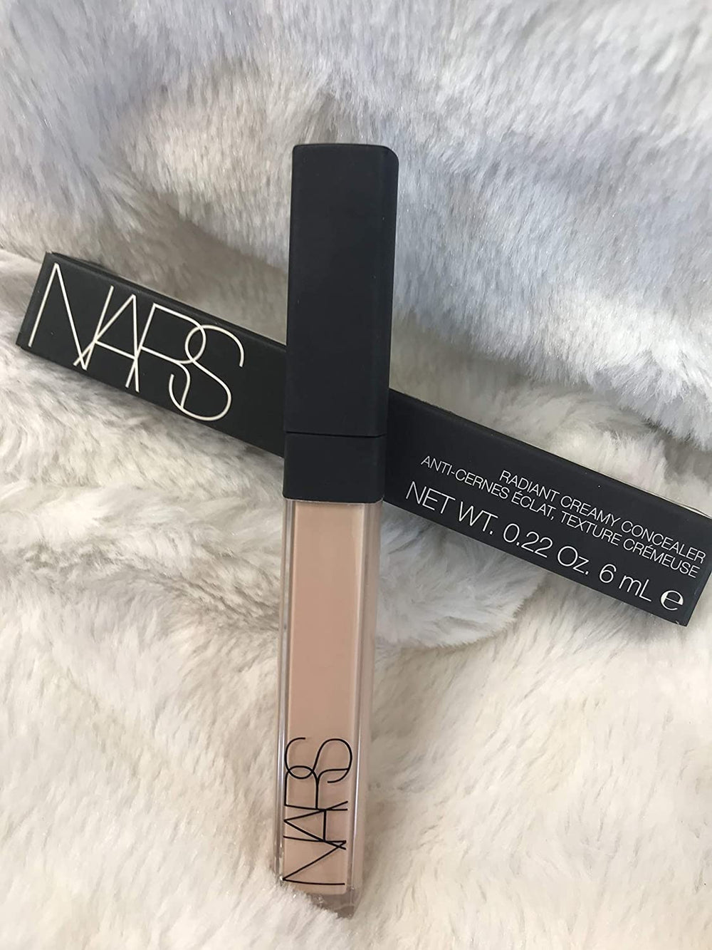 NARS concealer being applied under eye demonstrating brightening and crease-resistant benefit