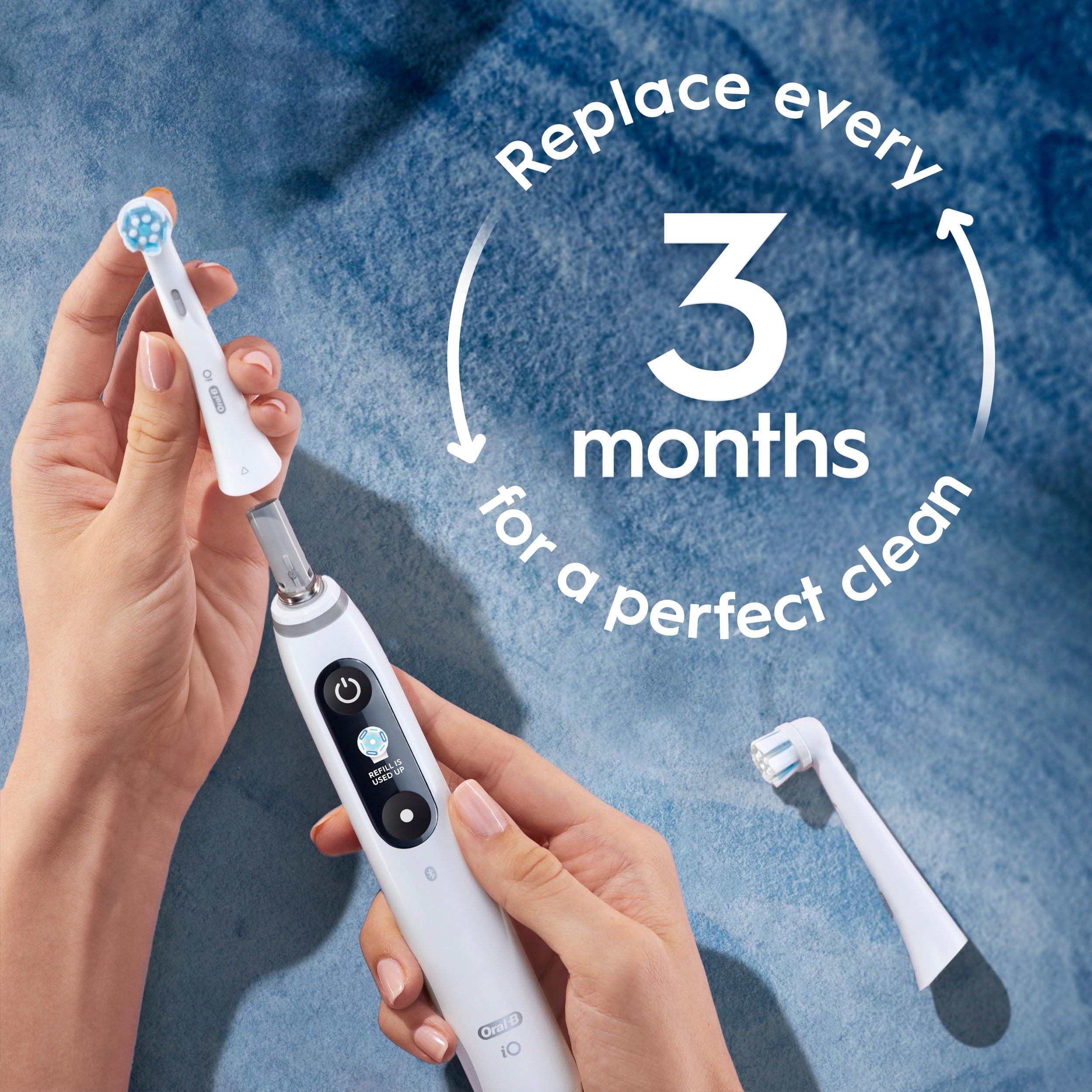 Oral-B brush head next to coin showing compact size and easy maneuverability benefit