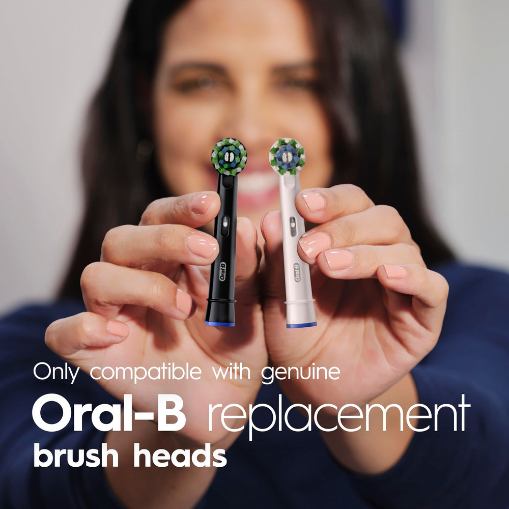 Open battery compartment on Oral-B Pro 100 showing easy battery replacement