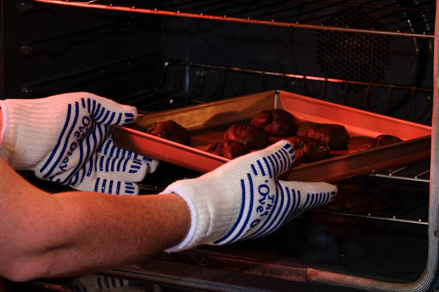 Ove Glove lifting hot oven pan showing secure grip and heat protection