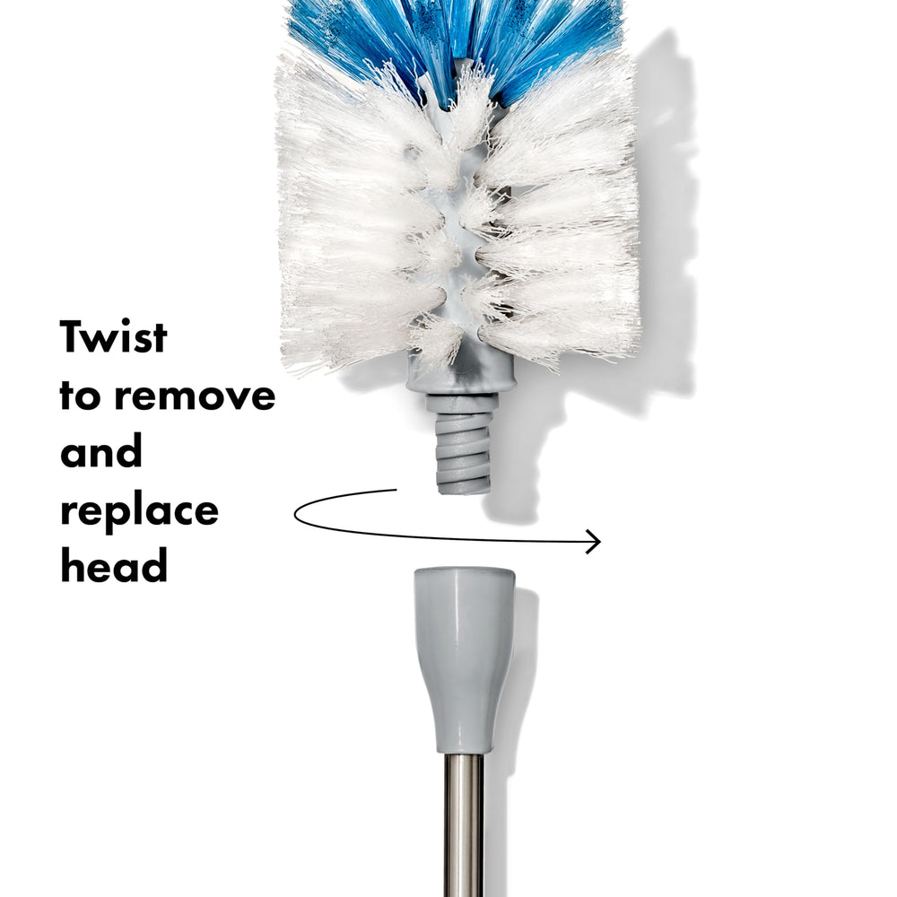 OXO brush in use inside tall water bottle reaches bottom for thorough cleaning