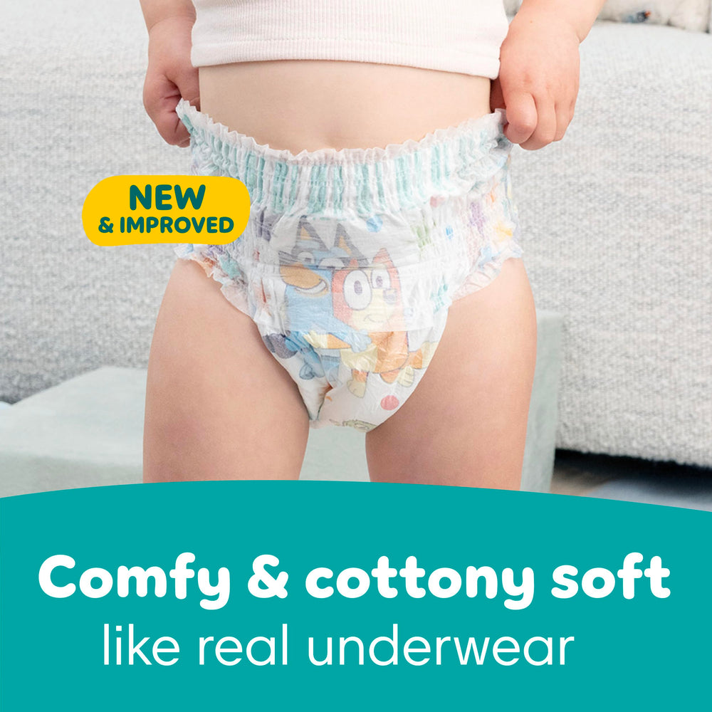 Toddler wearing Pampers Easy Ups pulling them up in playroom for practice