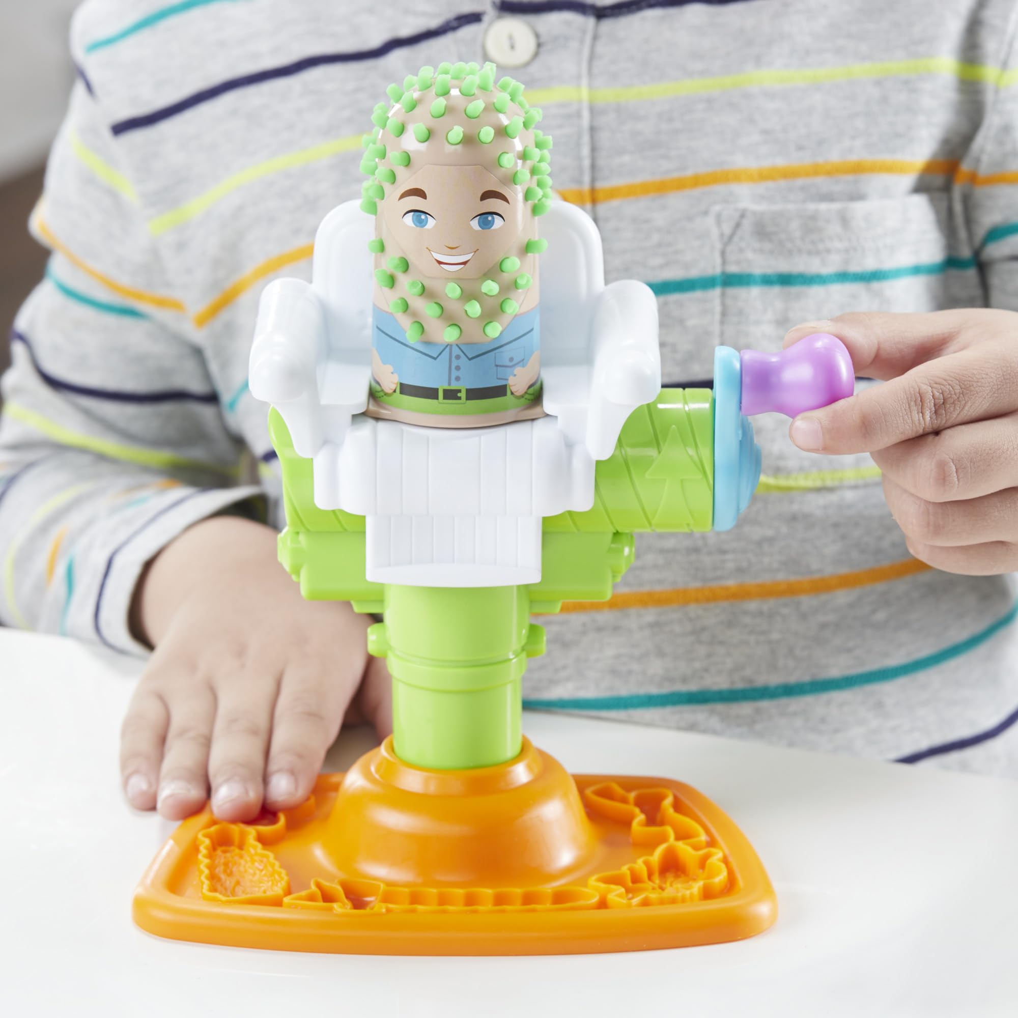 Play-Doh set next to a child’s hand to display scale and easy handling