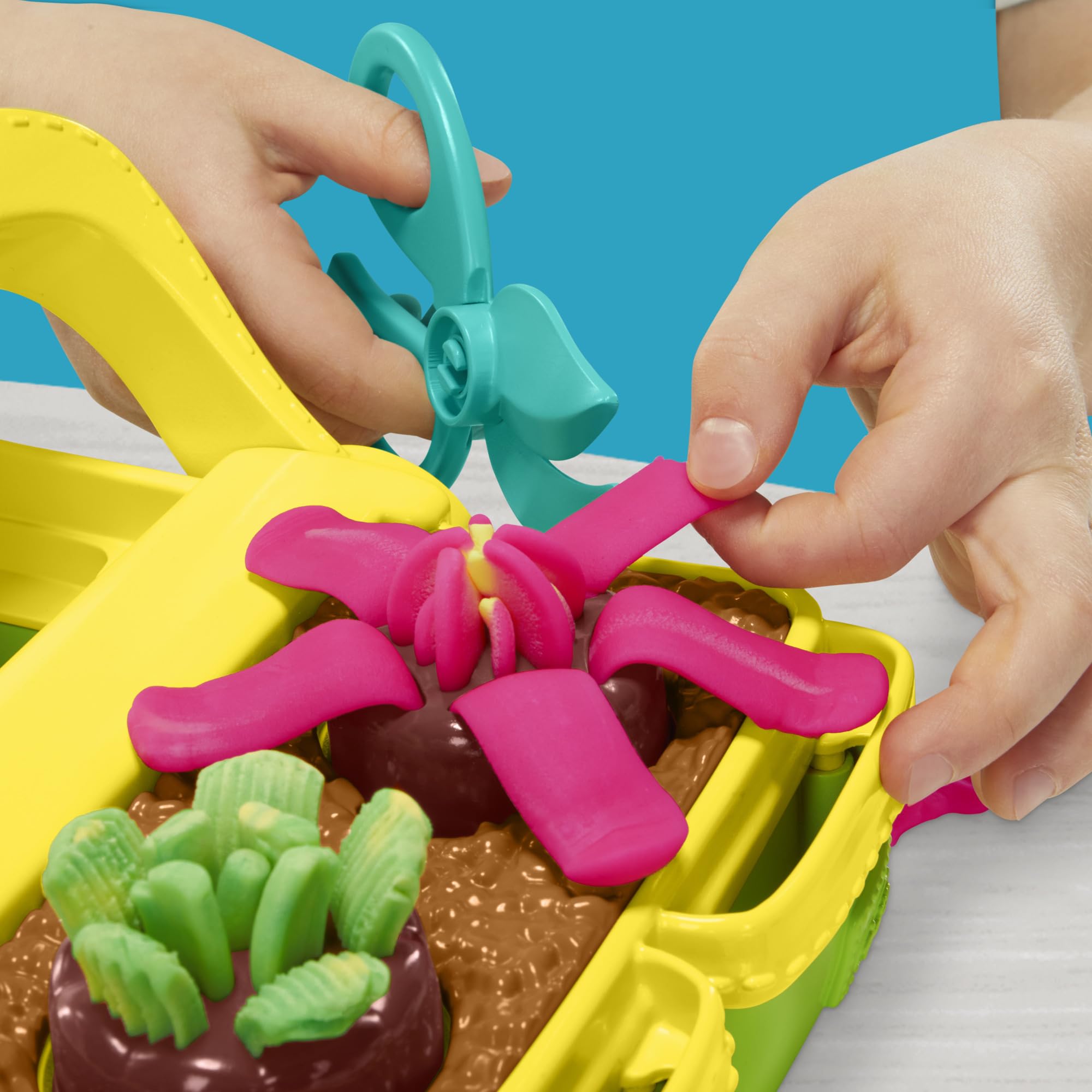 Play‑Doh pot and vase display holding stems for a custom child‑made bouquet