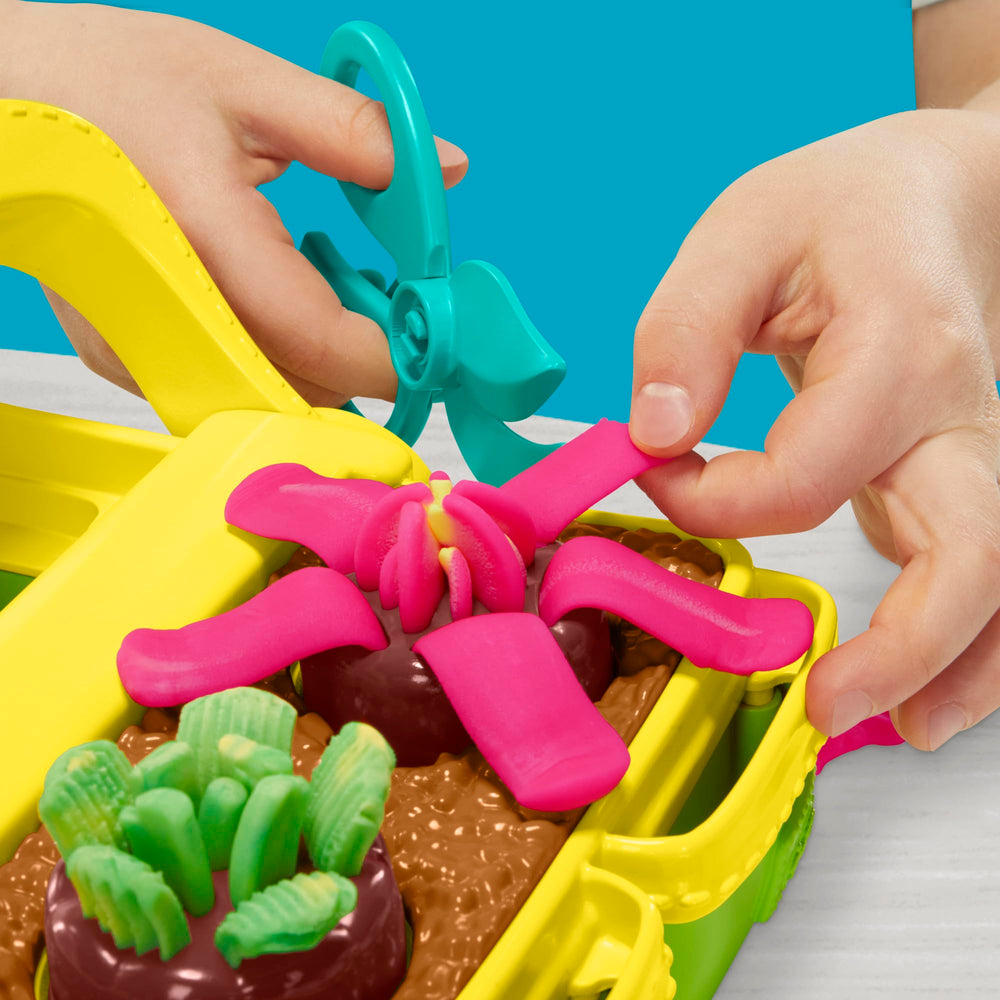 Play‑Doh pot and vase display holding stems for a custom child‑made bouquet