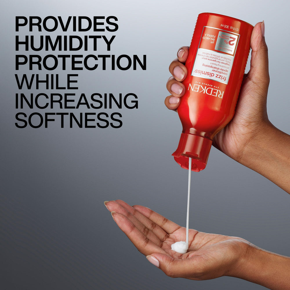 Redken Frizz Dismiss held in hand for scale showing 10.1 fl oz size and travel-friendly proportion