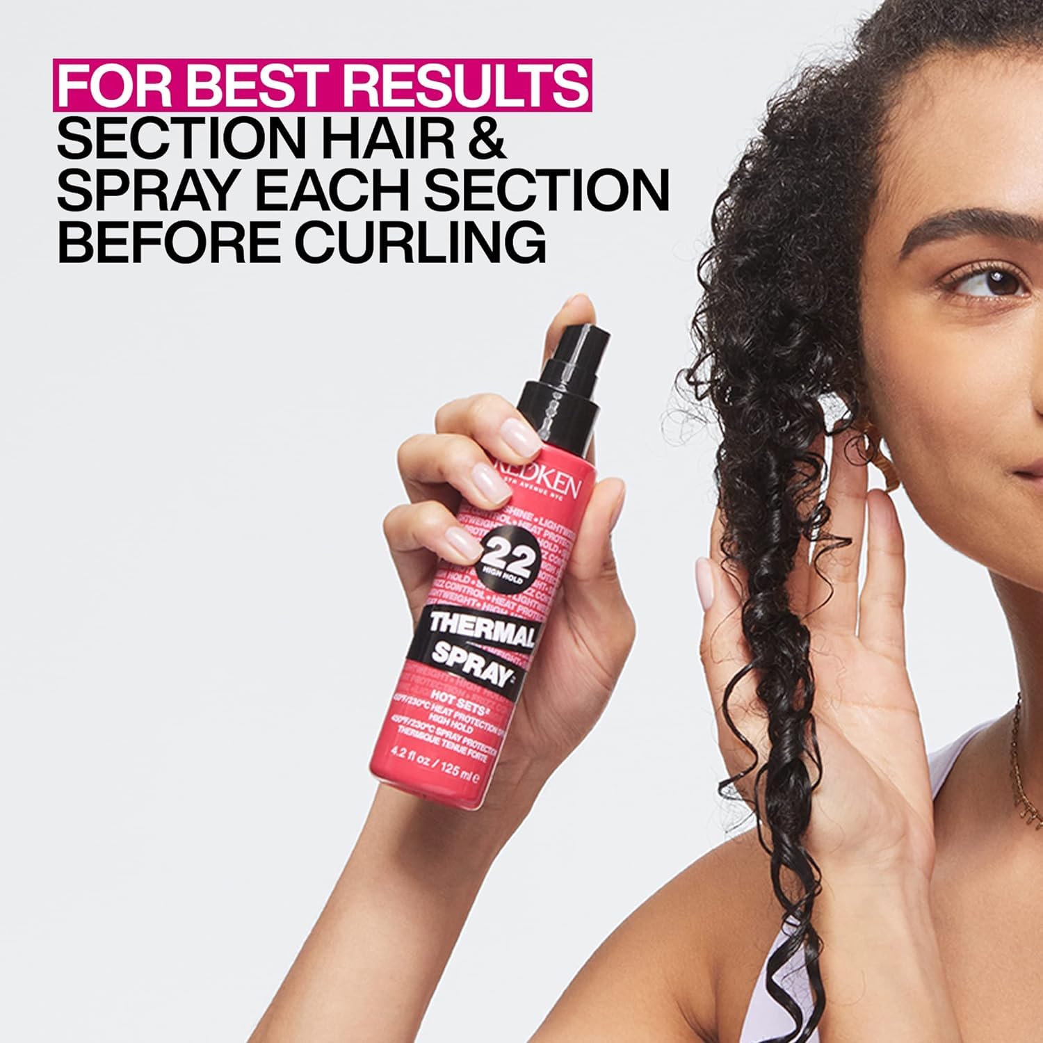 Redken bottle in hand for scale highlighting travel-friendly size and convenience