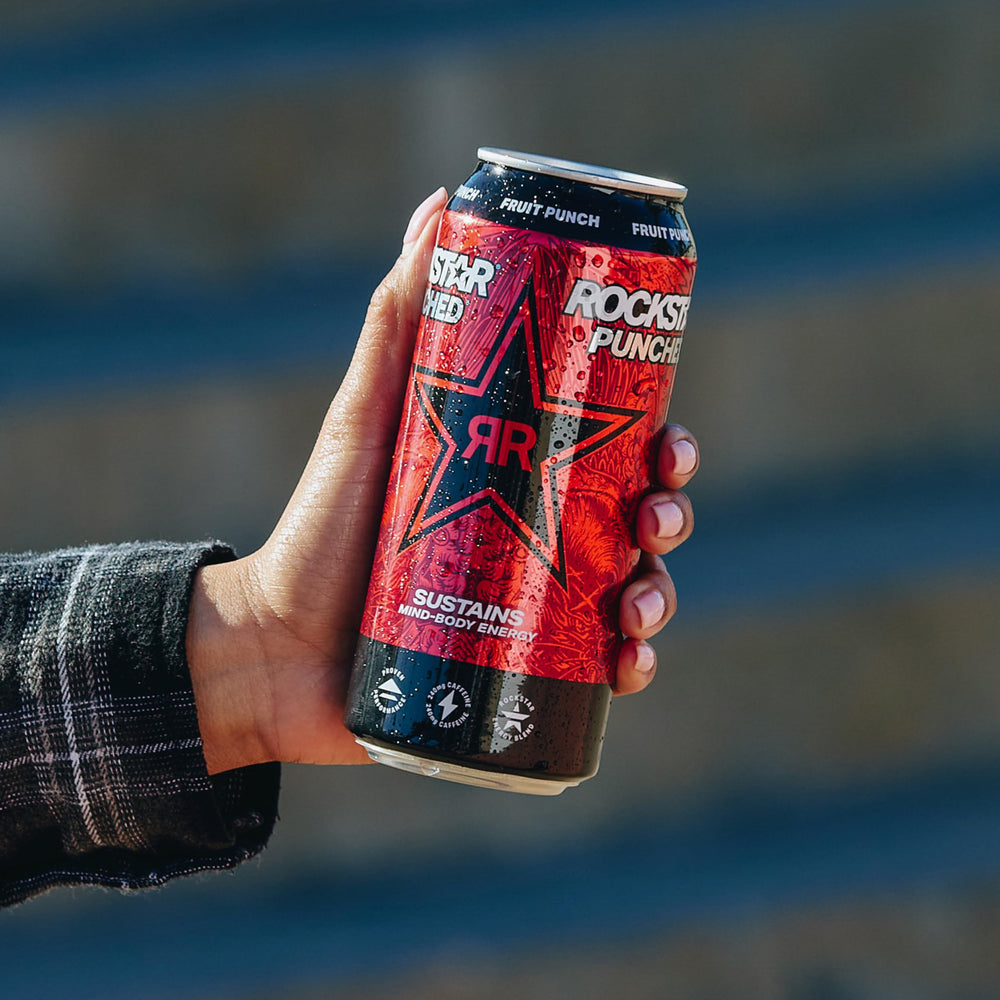Lifestyle shot of Rockstar can outdoors displaying convenient energy boost