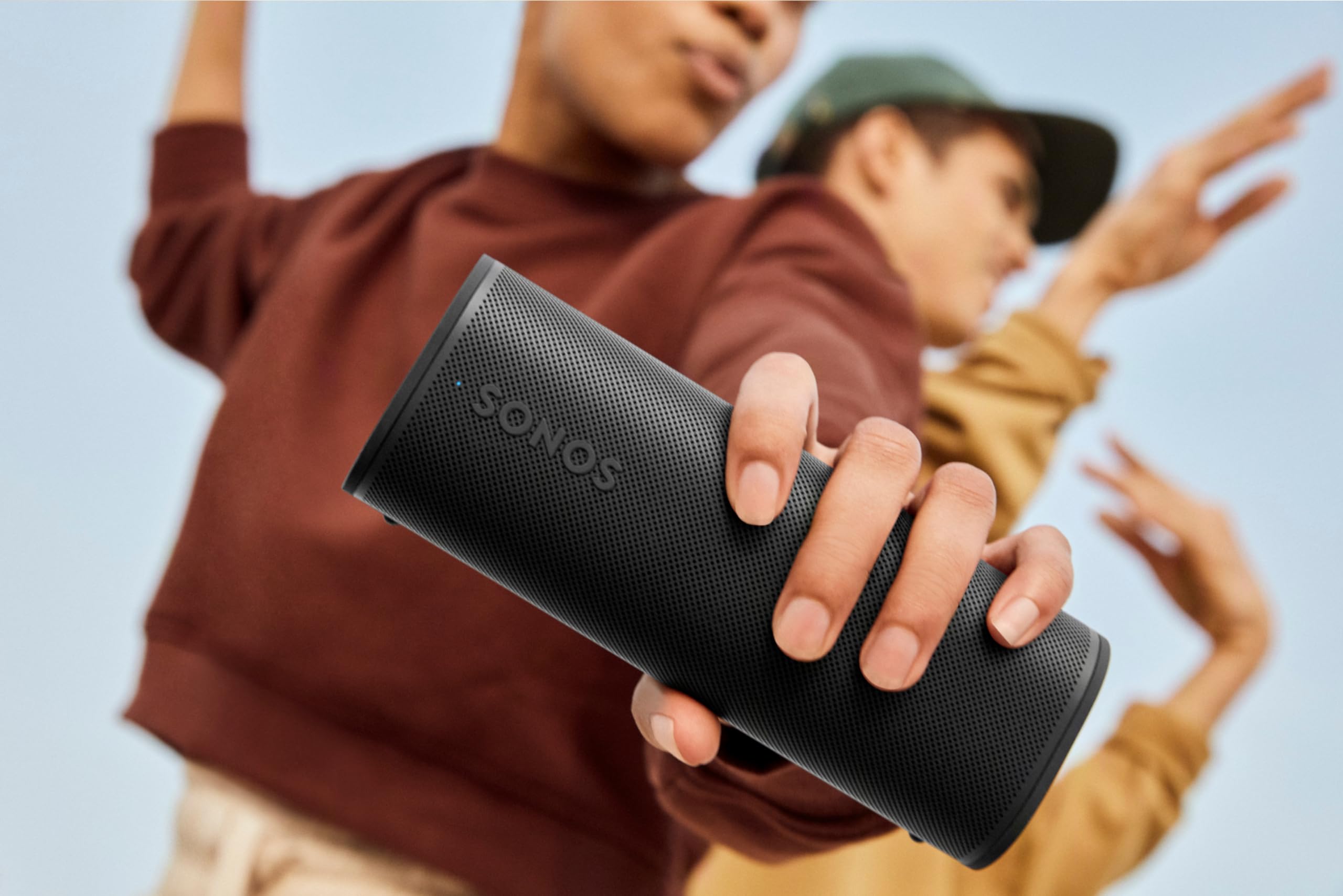 Sonos Roam 2 in a backyard setting playing music, Sonos multiroom and outdoor listening