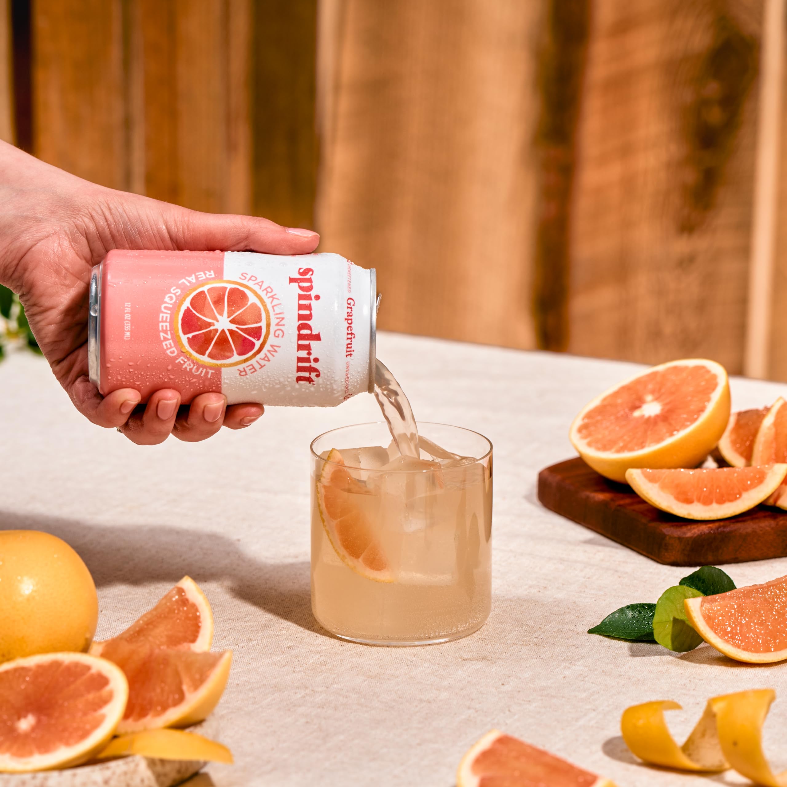 Spindrift grapefruit can next to a soda can showing 12 fl oz scale