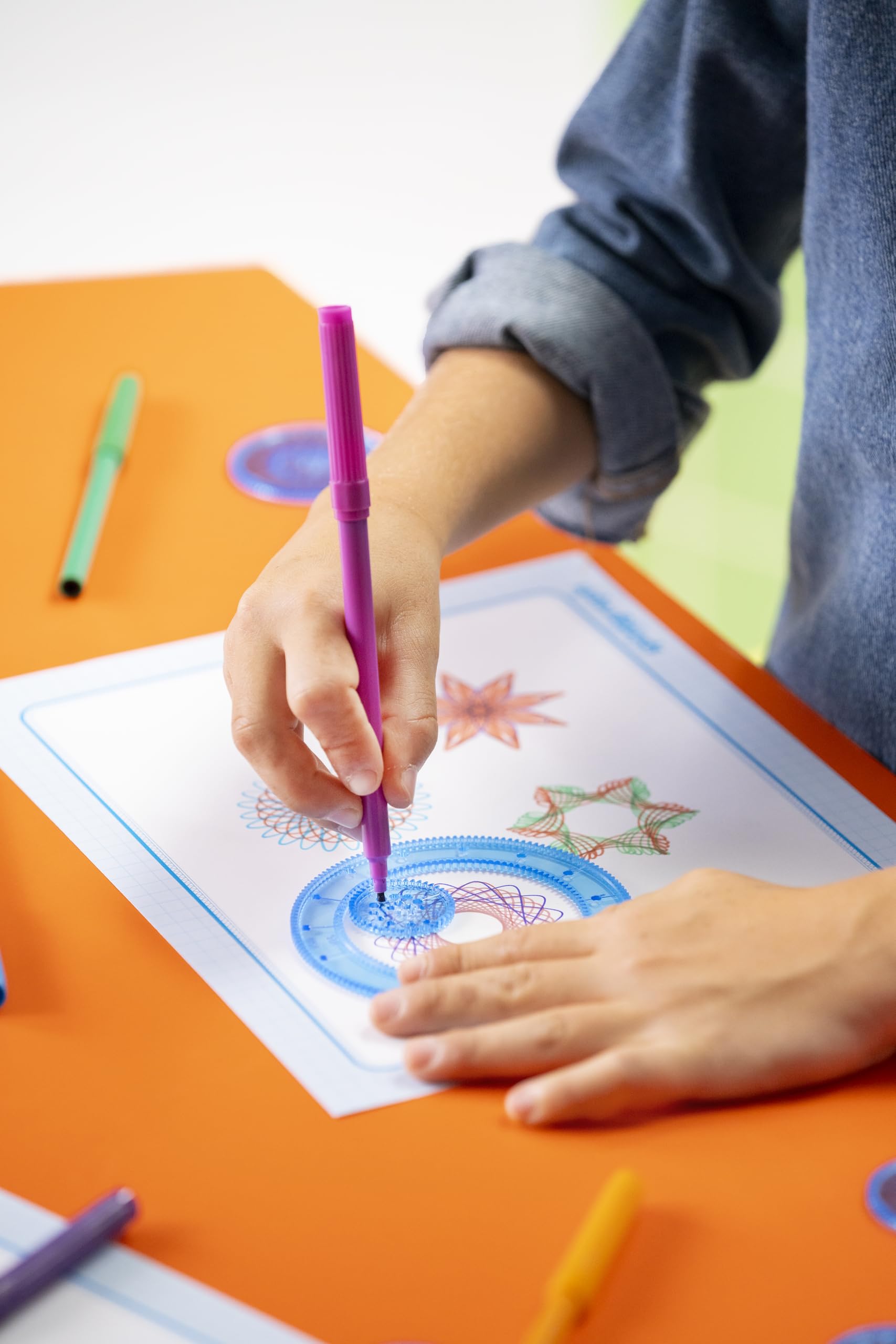 Spirograph pens and design paper laid out to show color options and texture