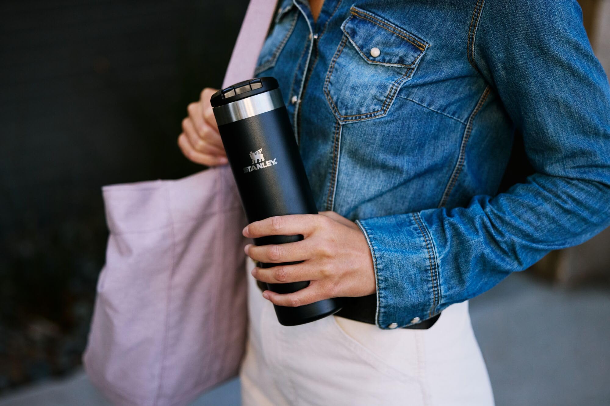 STANLEY mug next to smartphone showing 20 oz scale and easy carry benefit