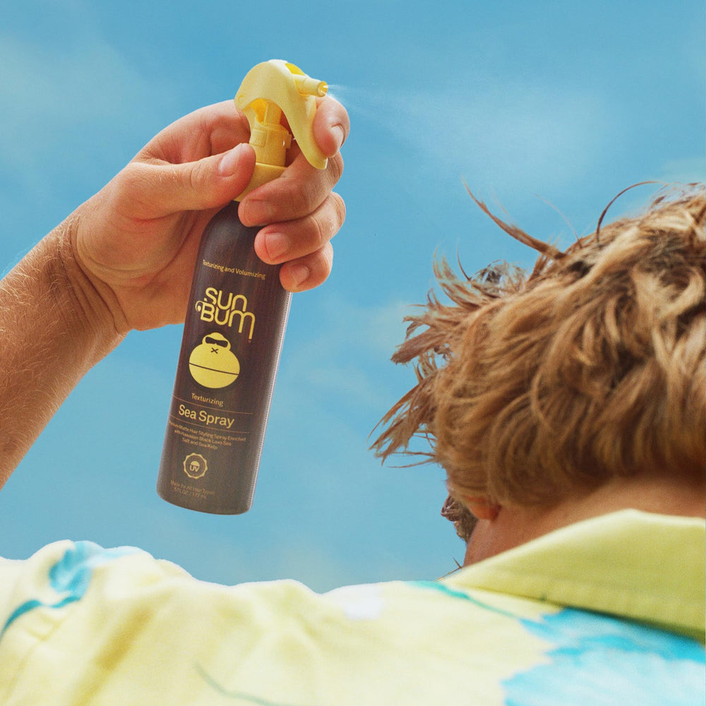 Sun Bum sea spray applied to damp hair while scrunching to create waves and volume