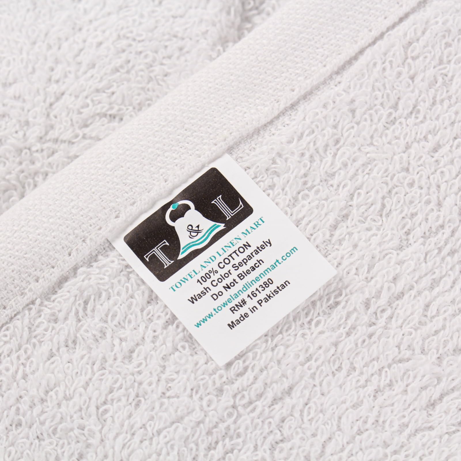T & L Towel and Linen Mart folded towels beside a ruler demonstrating size